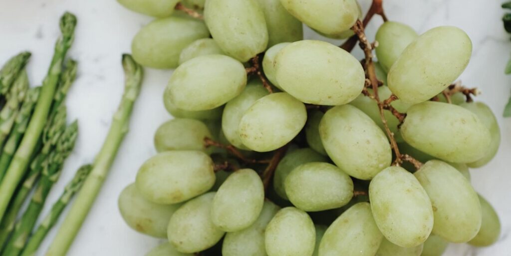 Frische grüne Weintrauben und Spargel – saisonales Obst und Gemüse von Merverd
